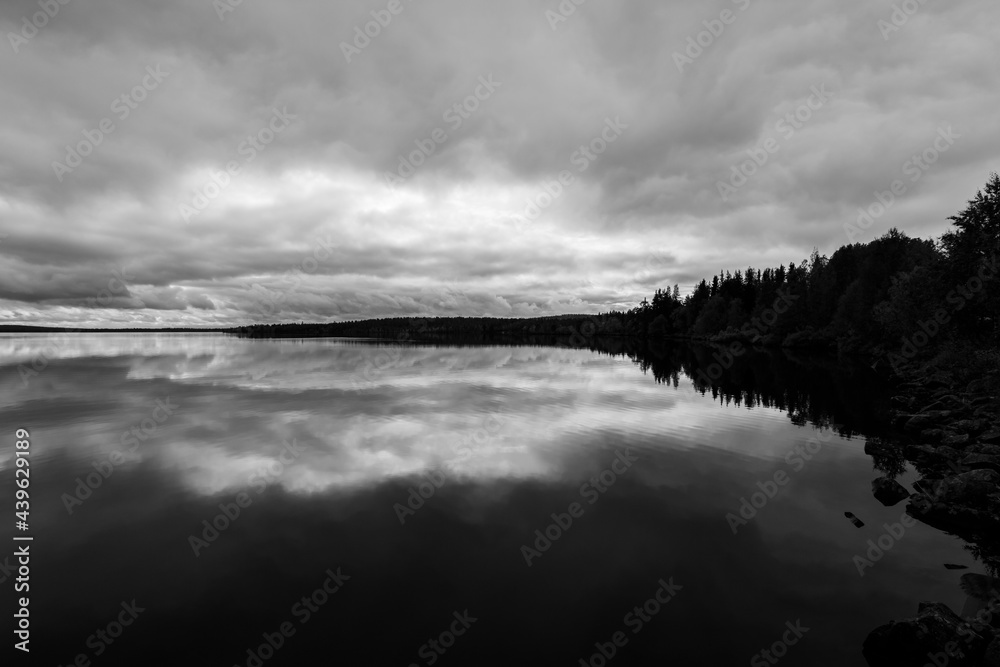Fototapeta premium Dramatic autumn clouds reflection in Muonio lake, Lapland, Northern Finland