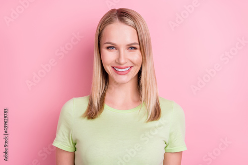 Photo of positive cheerful lovely pretty blonde lady shiny white smile wear green t-shirt isolated on pink background