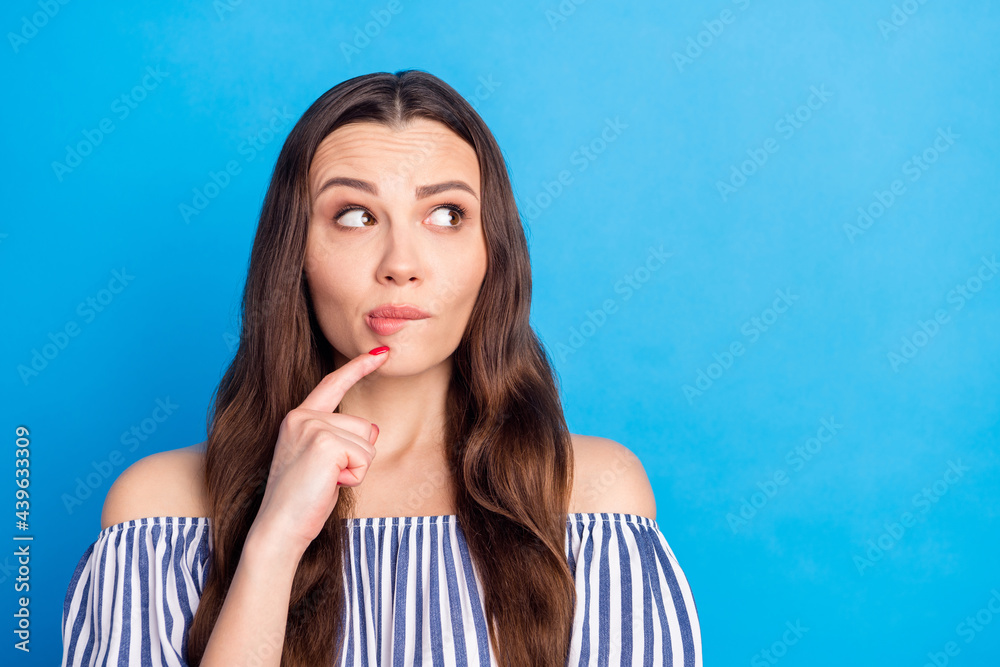 Photo portrait woman looking copyspace curious interested biting lip isolated vivid blue color background Photo portrait woman looking copyspace curious interested biting lip isolated vivid blue color background