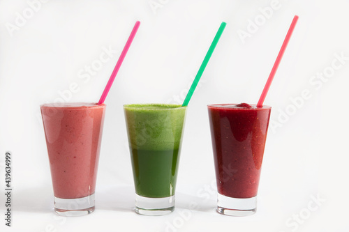 Green, pink and red milkshakes in a glass. Smoothie. on white background