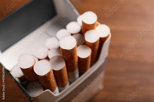 Pack of cigarettes on blurred background, closeup