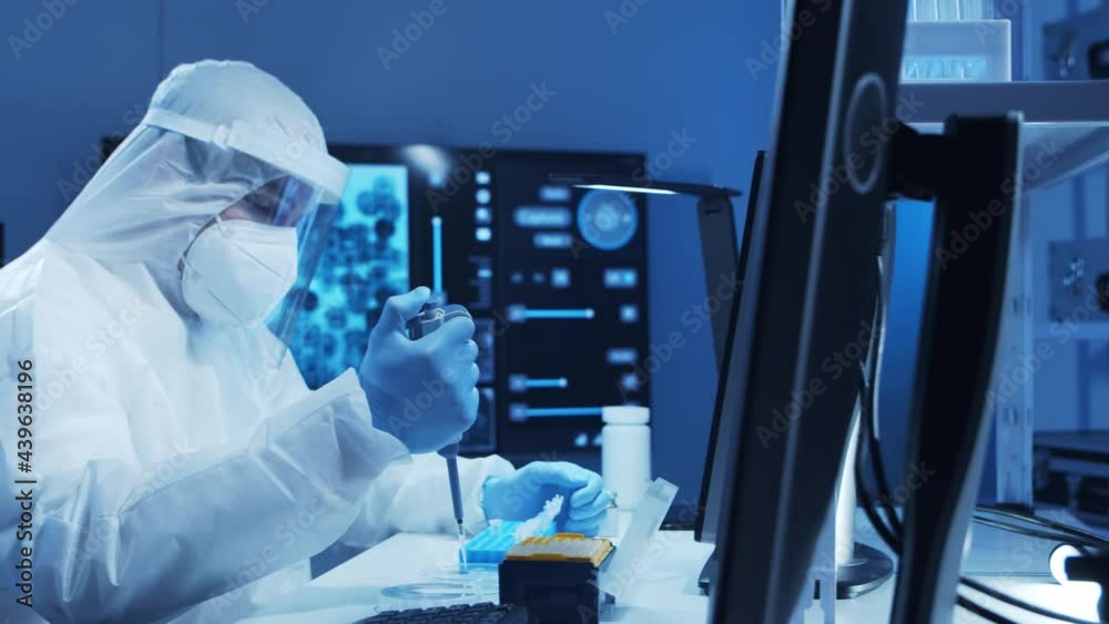 Doctor in protective suit is doing a science experiments and developing vaccine in a modern lab. Laboratory assistant workplace. The concept of science and medicine. Doctor in protective suit is doing a science experiments and developing vaccine in a modern lab. Laboratory assistant workplace. The concept of science and medicine.