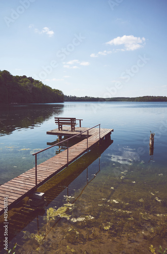 Wooden fishing and recreation platform at Lipie Lake on a sunny day, color toning applied, Poland.