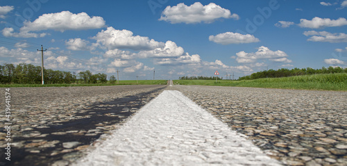 the road leading into the distance clouds and fields