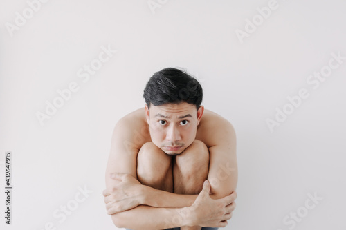 Lonely Asian man sit and rest on his knees. Concept of lonesome single man.