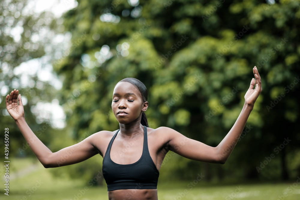 Young black woman doing meditation and yoga in a park. Young black woman doing meditation and yoga in a park.