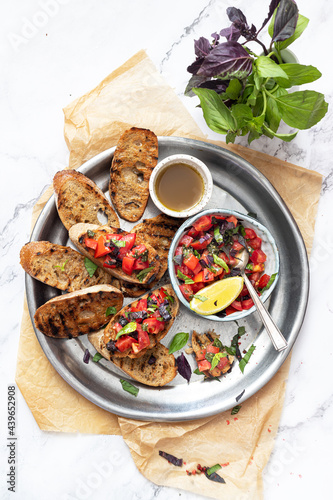 Bruschetta, on slices of toasted baguette garnished with basil © Vika