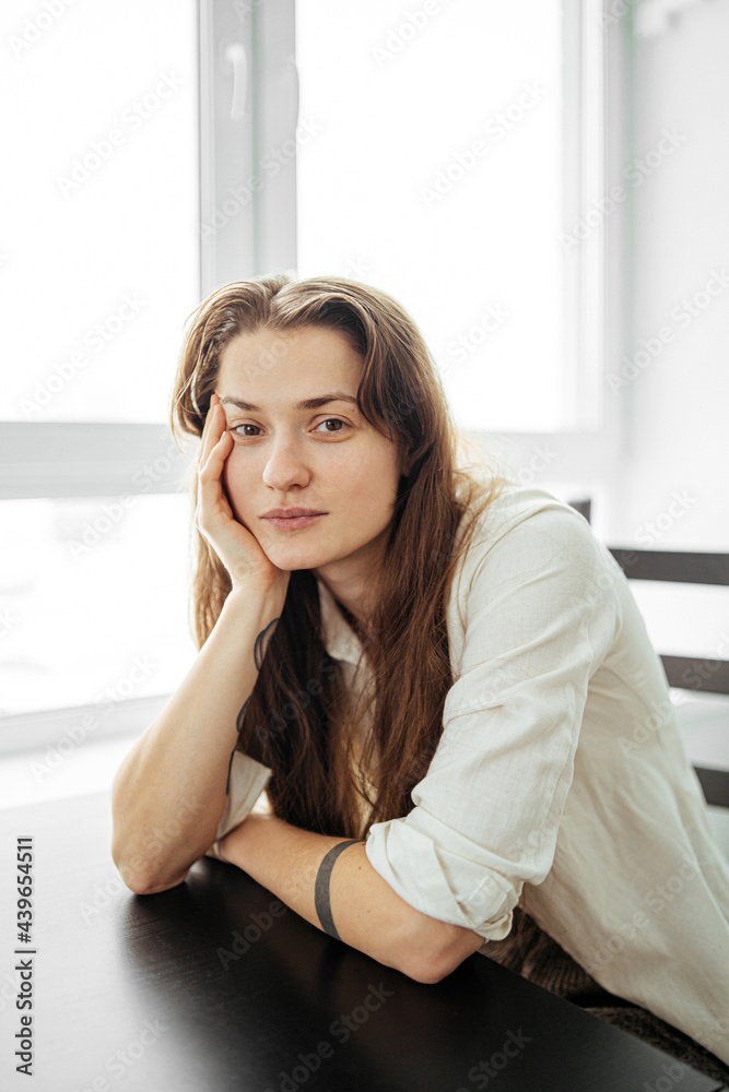 young woman sitting with her hands folded on the table young woman sitting with her hands folded on the table