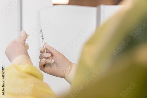 Close up of a hypodermic needle held by a health worker