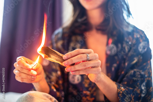 Woman burning palo santo wood at home