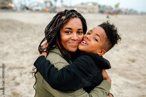 Beautiful Black mom hugging son at beach
