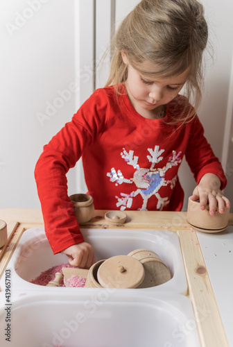 little girl playing with a valentines day kids sensory bin 