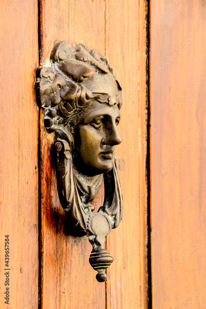 Vintage door knocker on brown wooden door