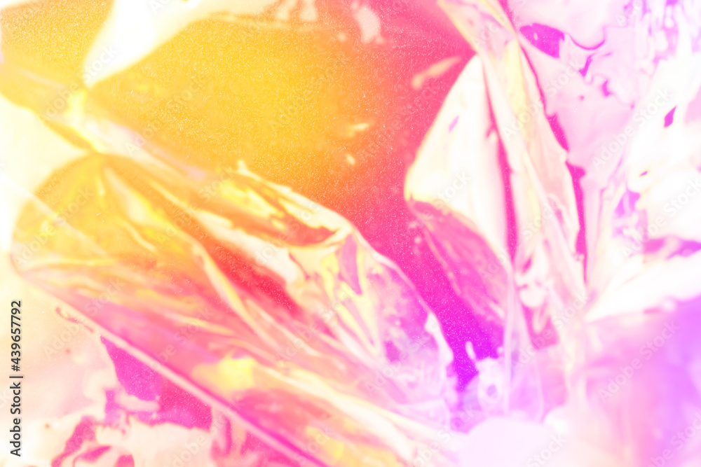 Blurred colorful holographic background. Defocused textured gradient in pink and yellow colors.
