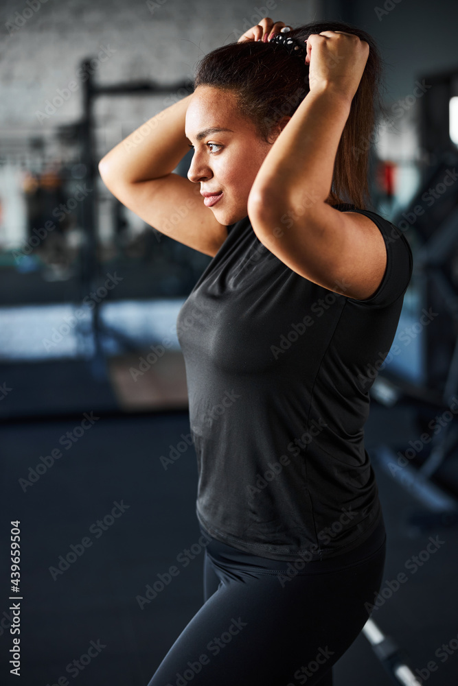 Smiling fit woman preparing for doing sport indoors