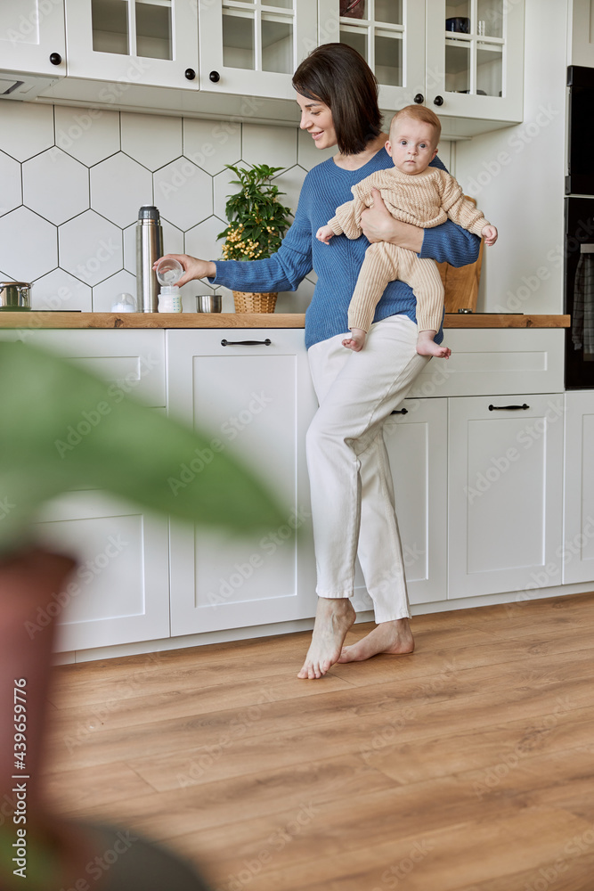 Mother pouring water into bottle for prepare milk