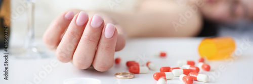 Bride in wedding dress lying on couch with handful of pills in her hand closeup