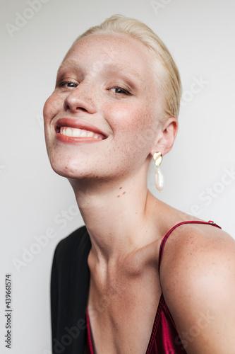 Model wearing red top and earrings