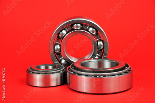 Metal bearings on a red background. Spare parts.