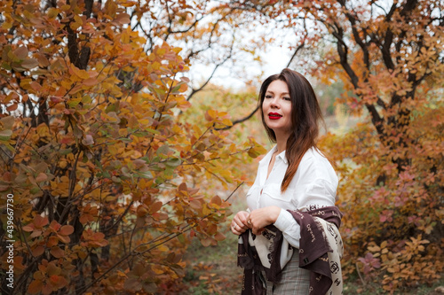 Portrait of a gorgeous middle-aged woman in an autumn park
