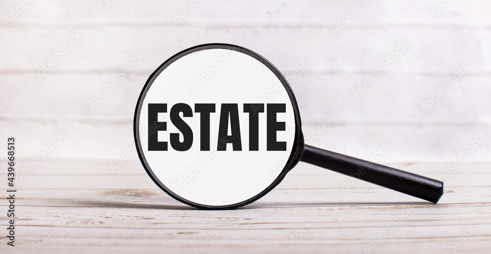 The magnifying glass stands vertically on a light background with the text ESTATE The magnifying glass stands vertically on a light background with the text ESTATE
