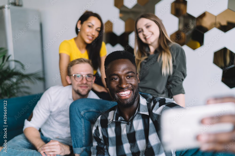 Obraz premium Smiling black man with friends taking selfie
