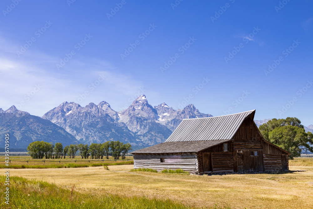 Wooden barn with Grand Teton mountain range in background Wooden barn with Grand Teton mountain range in background