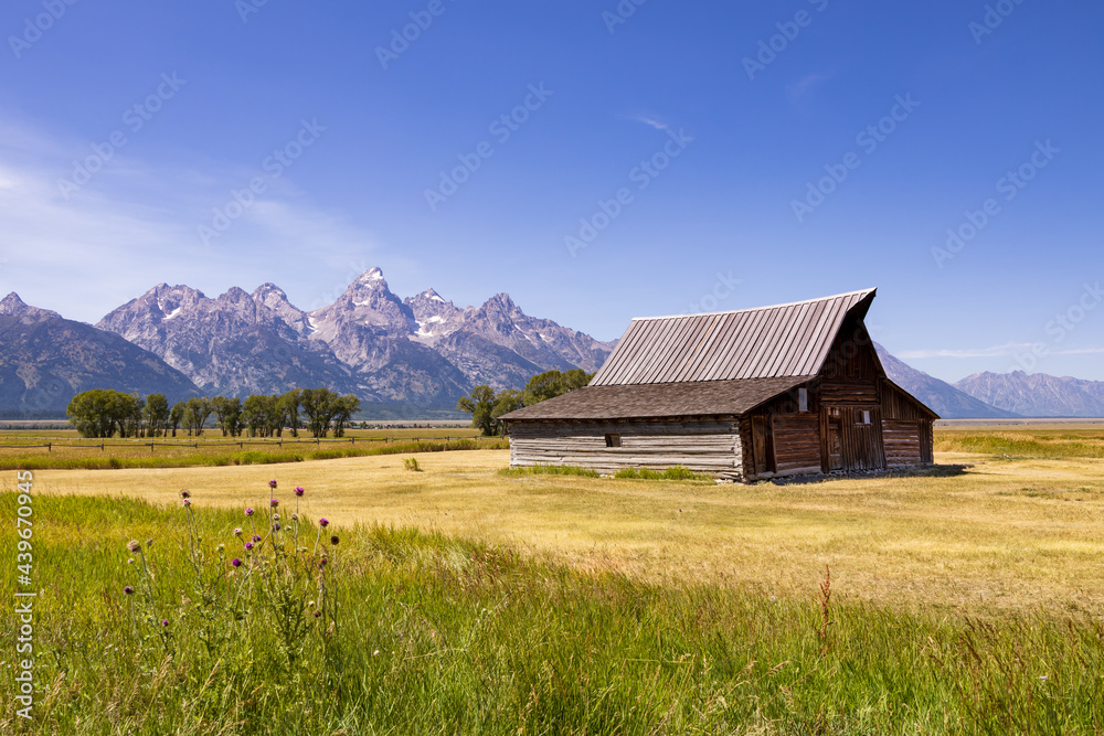 Wooden barn with Grand Teton mountain range in background Wooden barn with Grand Teton mountain range in background