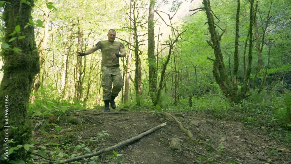 humor. sporty man in khaki clothes fooling around funny running and jumping through the forest. humor. sporty man in khaki clothes fooling around funny running and jumping through the forest.