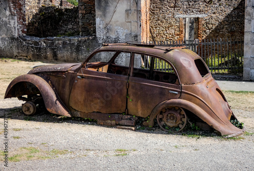An old abandoned rusty car left as a reminder to the horrors of war. War torn village in France. is left as a reminder  to the horrors of war. 2nd World War memorial site in France