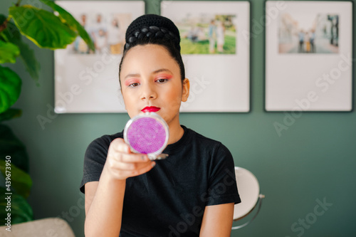 Pre-teen girl looking at a beauty mirror after got her makeup