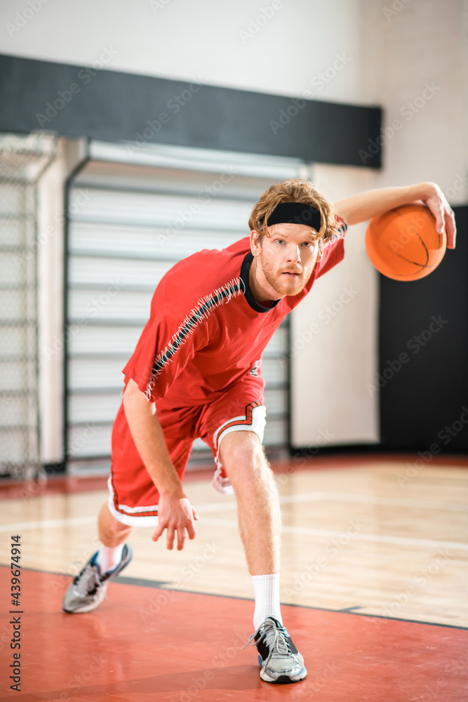 Ginger man in a red sportswear throwing the ball to the basket Ginger man in a red sportswear throwing the ball to the basket