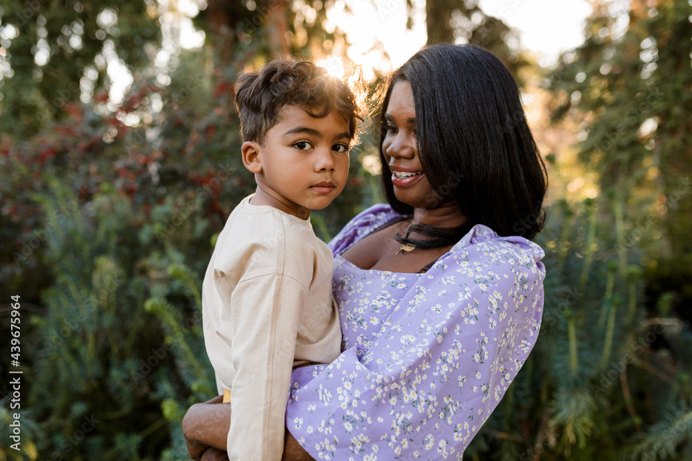Cute Child Looks into Camera While His Mother Lovingly Holds Him Cute Child Looks into Camera While His Mother Lovingly Holds Him