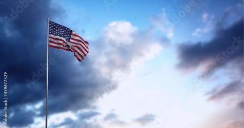 Canvas Print Composition of american flag on flagpole billowing over blue cloudy sky