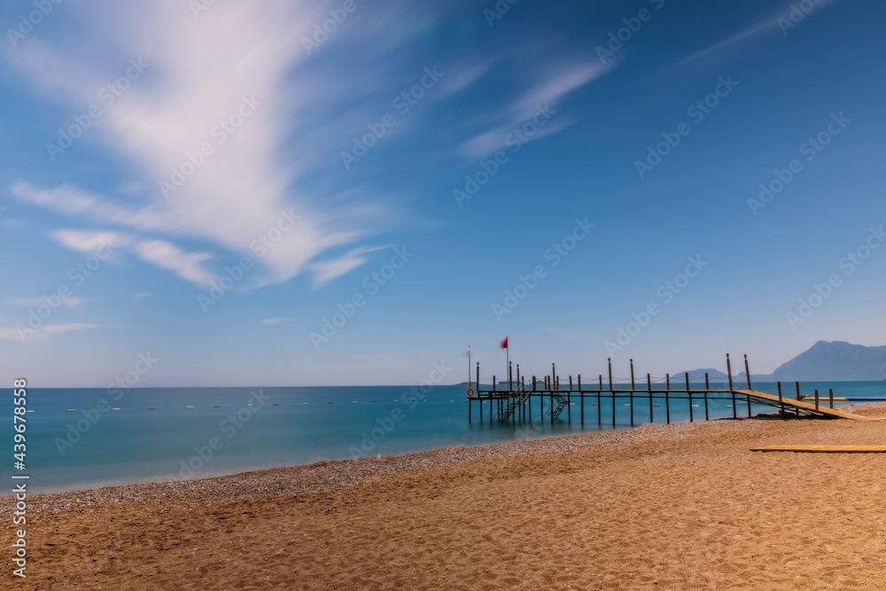 Beautiful beach with pier at the Mediterranean Resort in Turkey. Tekirova-Kemer. May 2021. Long exposure shot