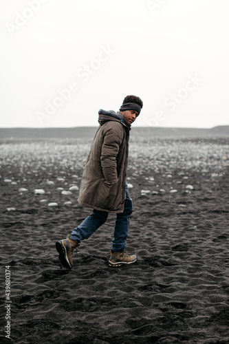 Portrait of an African American male hiker at the famous Black Sand Beach Reynisfjara in Iceland. photo