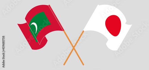 Crossed and waving flags of Maldives and Japan