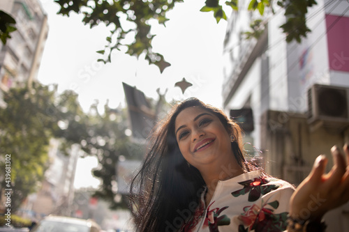 Indian woman laughing and making fun at outdoors in urban city