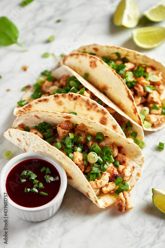 Tacos with meat and herbs, sauce and lime. National Mexican street food. On a light background.