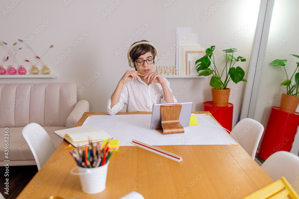 Boy wearing headphones and sitting at table Boy wearing headphones and sitting at table