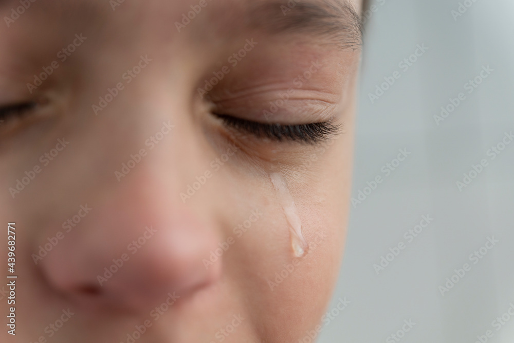 Tear rolls down the boy's cheek, his eyes are closed, he is upset and crying. Sad, unhappy emotions of child. Tear rolls down the boy's cheek, his eyes are closed, he is upset and crying. Sad, unhappy emotions of child.