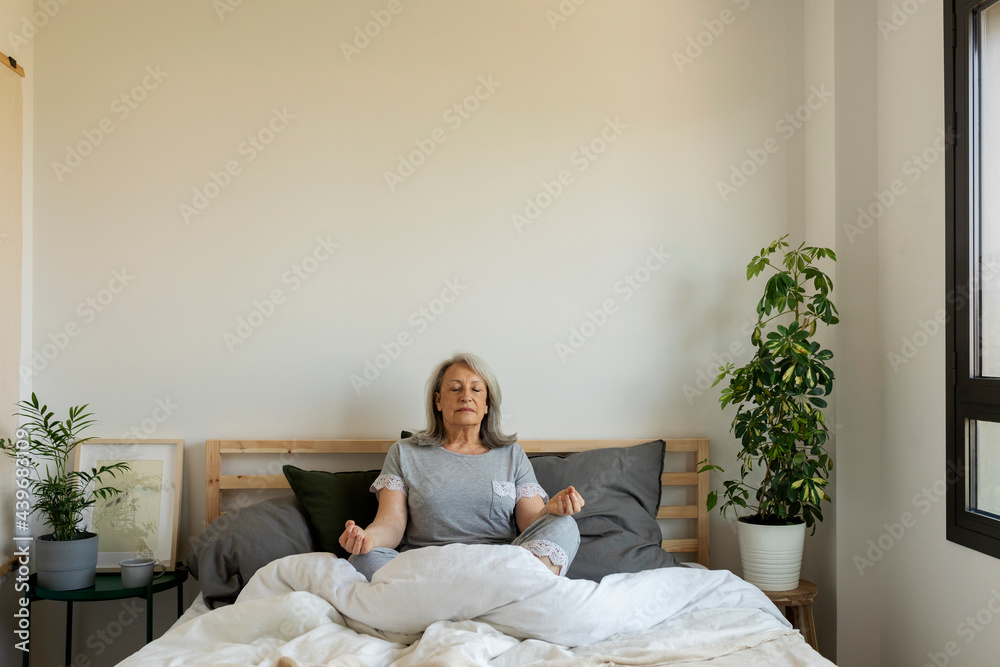 mature woman  meditating during morning time at home