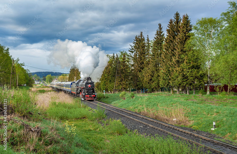 Obraz premium Vintage black steam locomotive train with wagons rush railway.