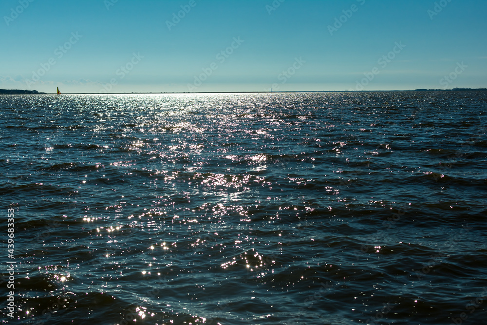 Sun glare in waves of sea water on a tropical beach in summer in nature ...