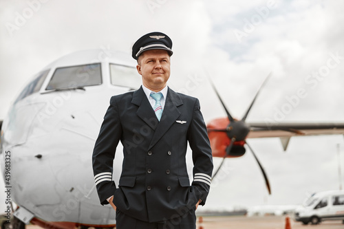 Pilot stand on runway on airplane jet background