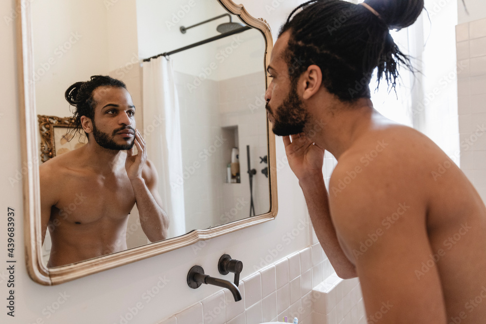 © Michela Ravasio/Stocksy - Guy in the bathroom during morning cleaning © Michela Ravasio/Stocksy - Guy in the bathroom during morning cleaning