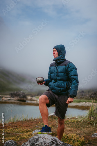 Male traveler with bowl in countryside
