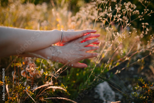 young woman touching grass softly