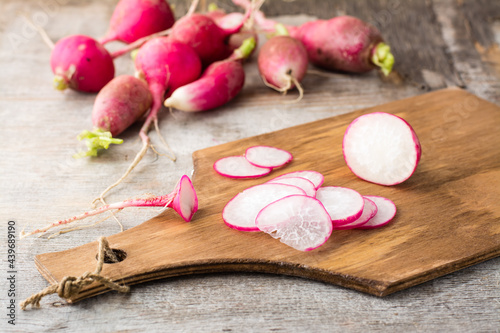 Fresh sliced radish on a cutting board on a wooden table. Vegetables for a vegetarian diet. Rustic style
