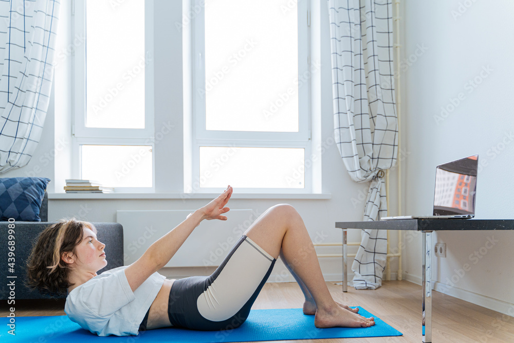 Fit woman doing abs exercise during online fitness workout Fit woman doing abs exercise during online fitness workout